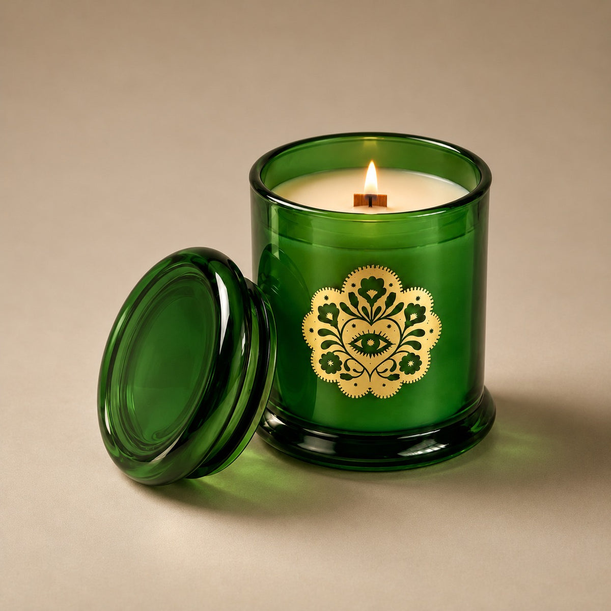 Lit Miss Sparkle soy candle with its green glass lid alongside