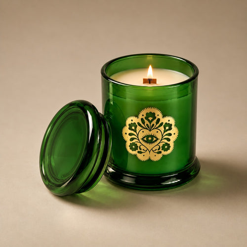 Lit Miss Sparkle soy candle with its green glass lid alongside