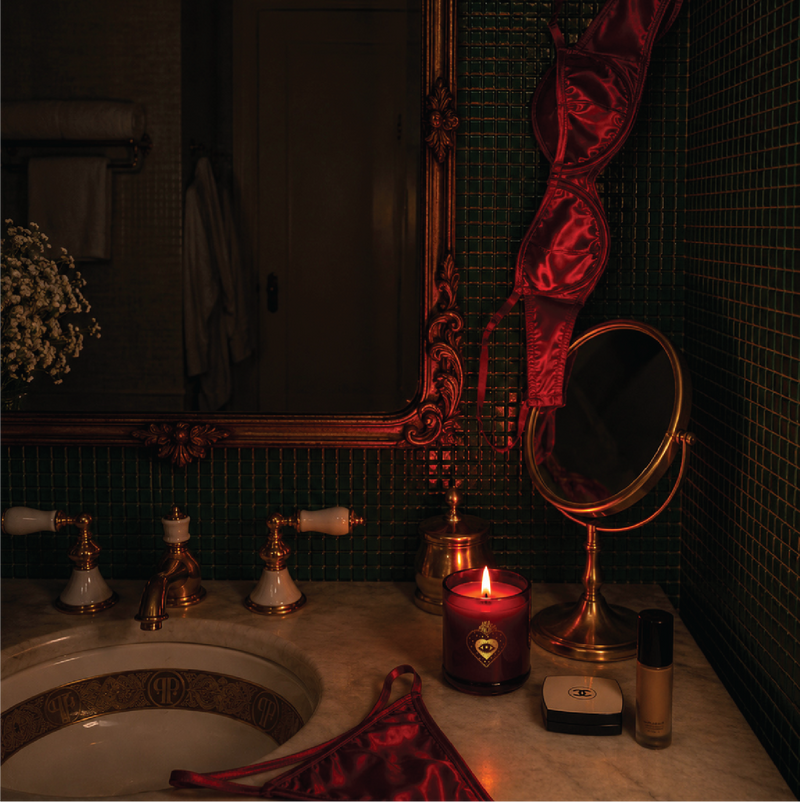 Lit Miss Sparkle candle beside a bathroom basin and mirror