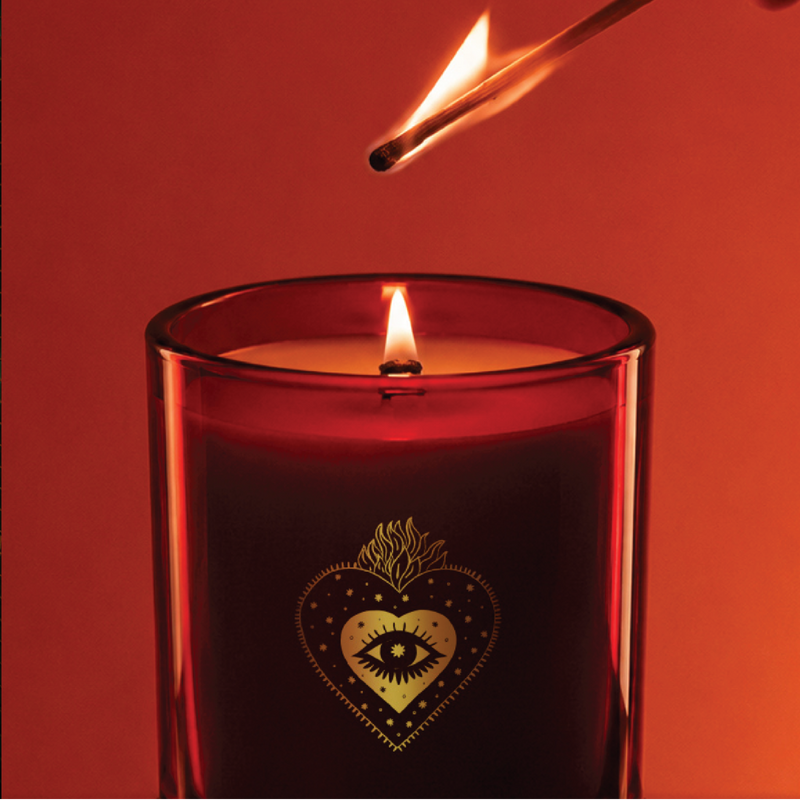 A match lighting a red Miss Sparkle candle